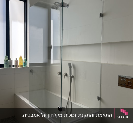אמבטיון זכוכית שקוף מותקן על אמבטיה בחדר רחצה מודרני